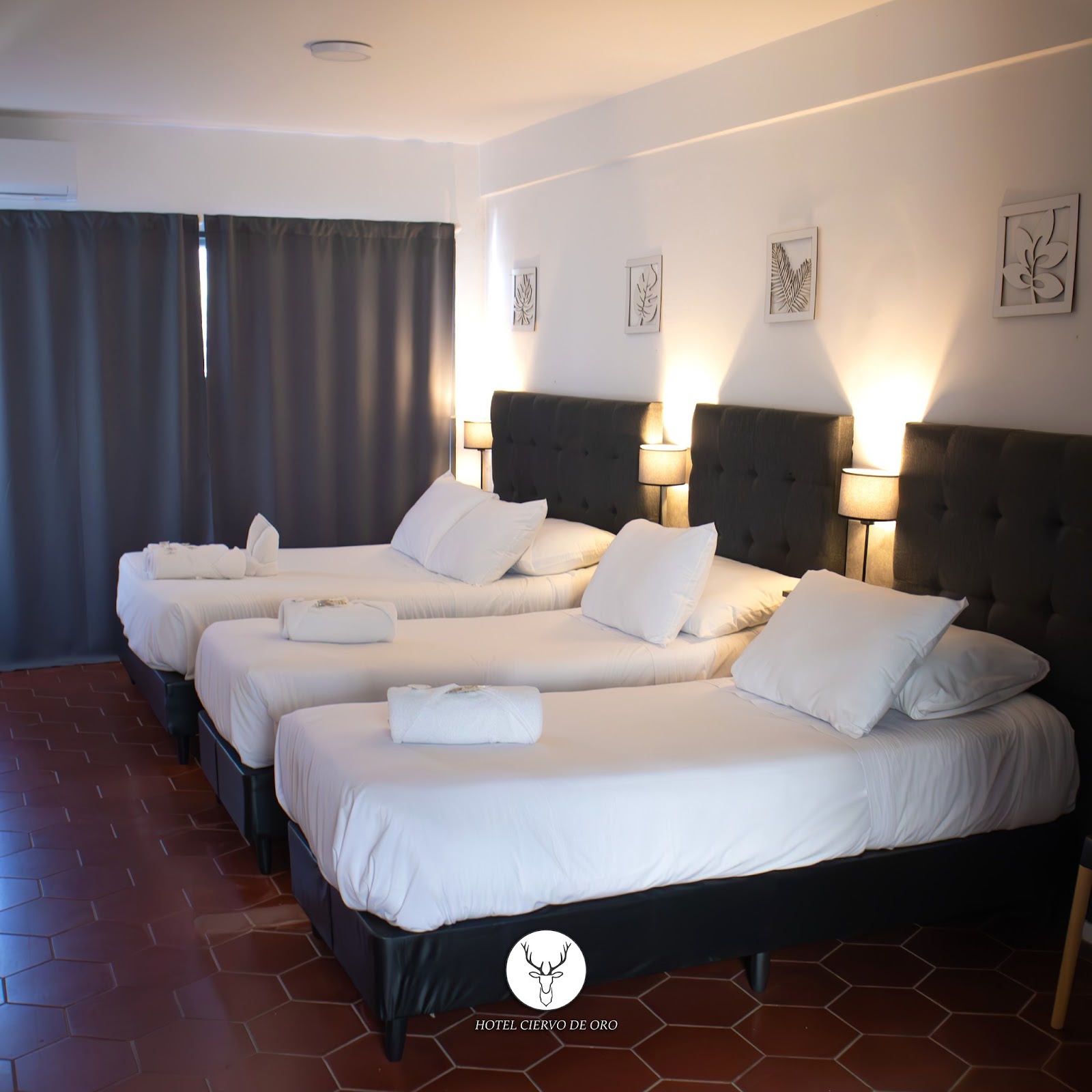 Habitación amplia con tres camas y vista, ropa de cama blanca